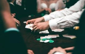 Hände von Pokerspielern mit Karten und Chips