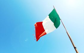 Italienische Flagge vor blauem Himmel.