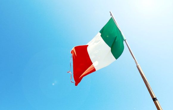 Italienische Flagge vor blauem Himmel.