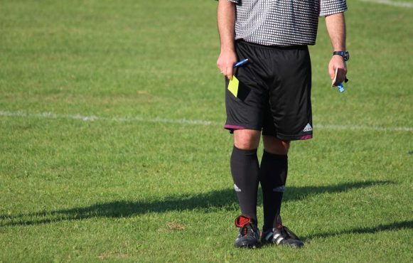 Aufnahme eines Schiedsrichters mit einer gelben Karte in der Hand.