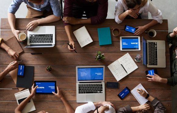 Marketingteam mit Laptops an einem Tisch.