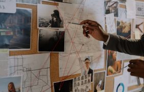 Ermittler vor Tafel mit Hinweisen.