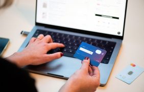 Eine Frau mit einer Kreditkarte an einem Laptop