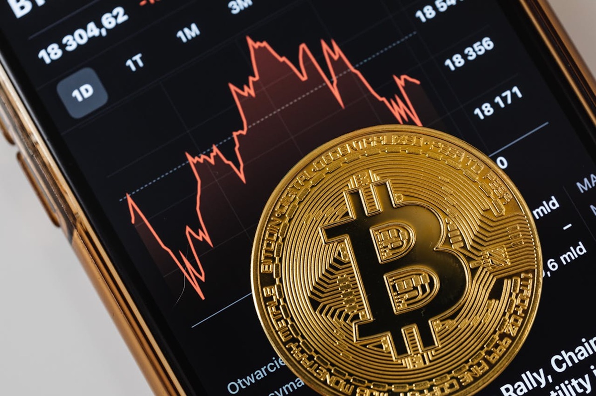 Bitcoin-Chart mit Bitcoin-Münze im Vordergrund