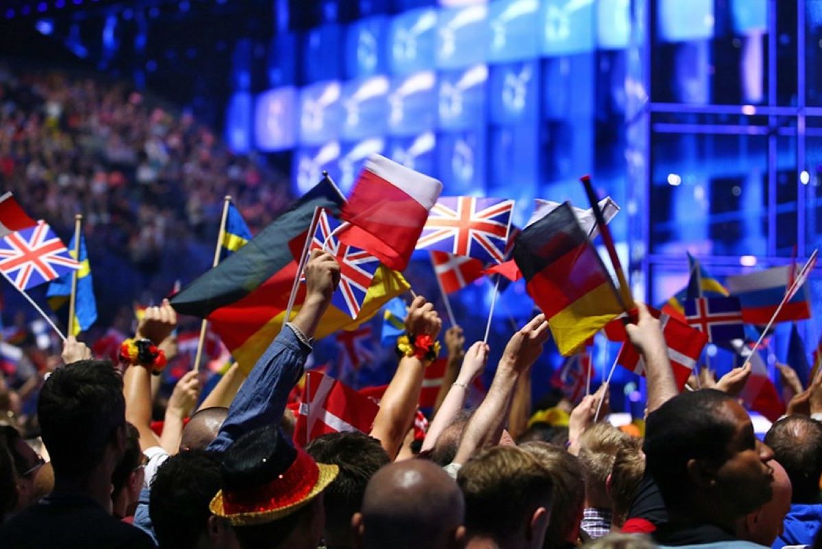Aufnahme eines Publikums mit Länderflaggen in den Händen.