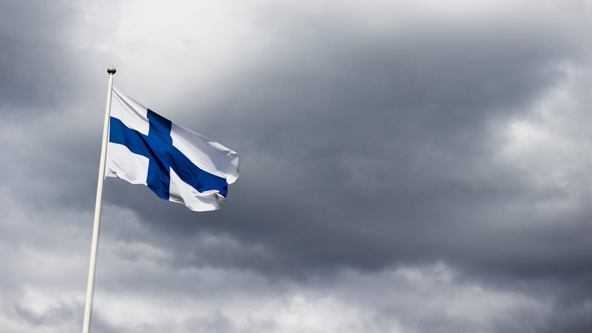 Finnische Flagge vor bewölktem Himmel