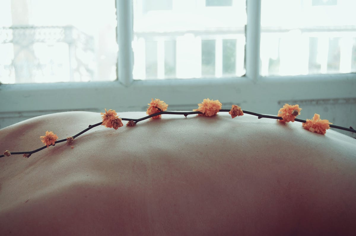 Blüten auf Rücken einer Person.