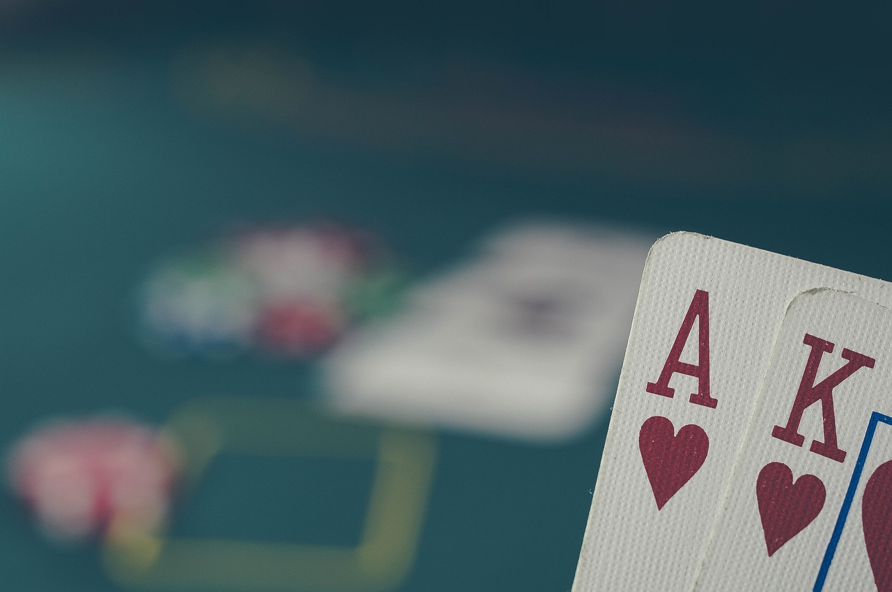 Person mit Pokerkarten in der Hand.