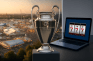 Panoramablick auf das Oktoberfest, der Champions-League-Pokal und ein Laptop, auf dem Slots gespielt werden.