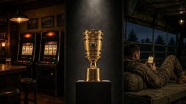 Zwei Spielautomaten in einer Kneipe, der DFB-Pokal und ein Soldat spielt Slots auf seinem Smartphone.