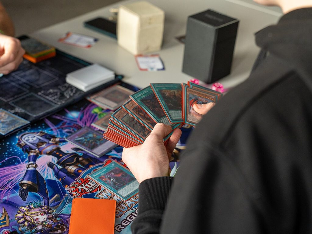 Ein Spieler hält mehrere Yu-Gi-Oh!-Karten in der Hand.