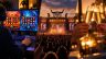 Auf einem Bildschirm sind zwei Slots zu sehen. Eine Bühne auf dem Wacken-Festival. Zwei Personen stoßen mit Sekt an.